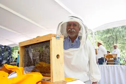 Un productor local posa junto a un m&oacute;dulo de exhibici&oacute;n de abejas y panales, en el marco del D&iacute;a Mundial de las Abejas y las acciones de fomento a esta actividad estrat&eacute;gica en Guanajuato.